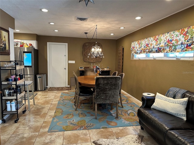 dining space featuring a chandelier and a textured ceiling