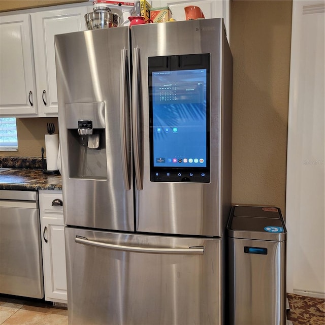 kitchen with white cabinets, light tile patterned floors, and appliances with stainless steel finishes