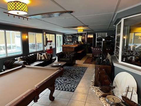 rec room with light tile patterned flooring, bar, and pool table