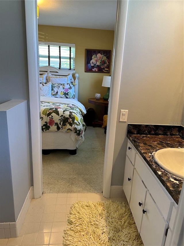 ensuite bathroom featuring ensuite bath, vanity, and baseboards