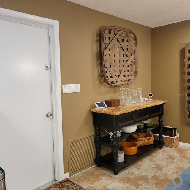 interior space with baseboards, visible vents, and a textured ceiling