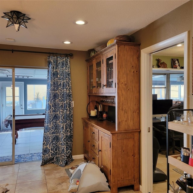 interior space with light tile patterned floors, baseboards, a healthy amount of sunlight, and recessed lighting