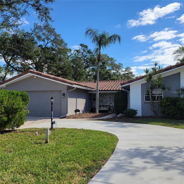 ranch-style house with stucco siding, driveway, a tile roof, a front yard, and a garage