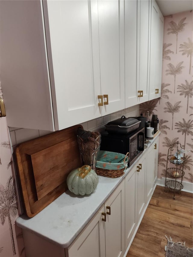 bar featuring white cabinetry and light hardwood / wood-style floors