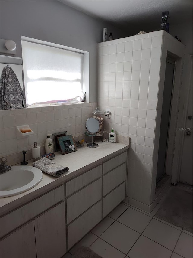 bathroom with tile patterned floors, vanity, and tile walls