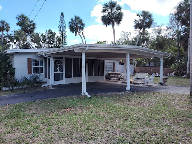 exterior space featuring a sunroom and a lawn