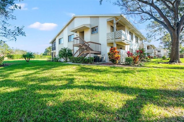 exterior space featuring a lawn, central AC, and a balcony