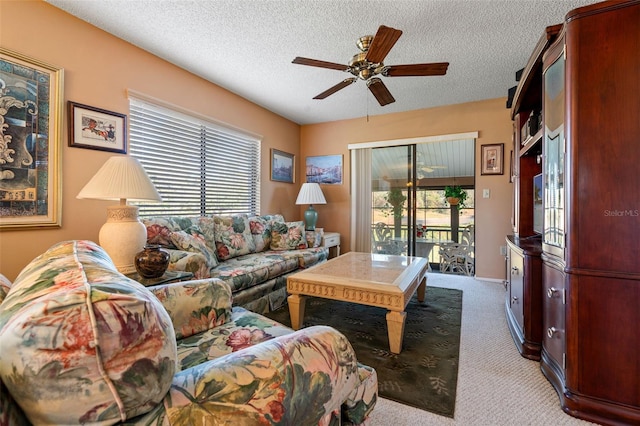 carpeted living room with ceiling fan and a textured ceiling