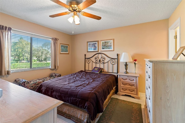 carpeted bedroom featuring ceiling fan and a textured ceiling