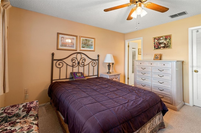 carpeted bedroom with ceiling fan and a textured ceiling