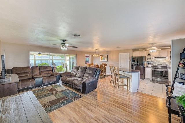 living room with light wood-type flooring and ceiling fan