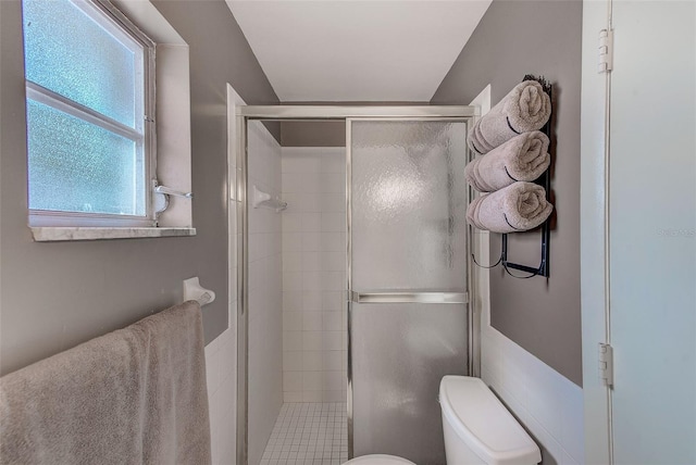 bathroom featuring toilet and a shower with shower door