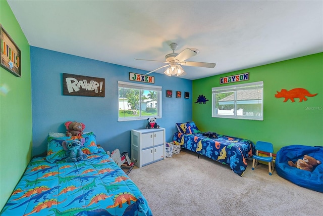 bedroom with light colored carpet, multiple windows, and ceiling fan