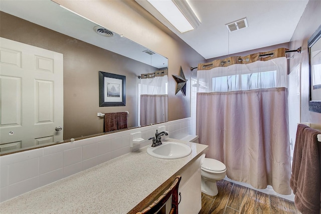 bathroom featuring plenty of natural light, vanity, wood-type flooring, and toilet