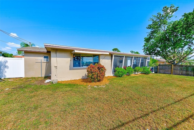 back of house featuring a sunroom and a yard