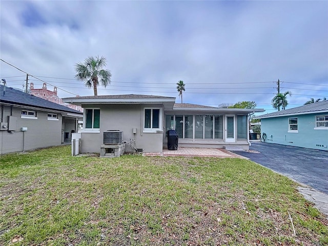 3505 Casablanca Ave, St Pete Beach, FL 33706 - rear view of property featuring stucco siding, a lawn, central air condition unit, and a patio