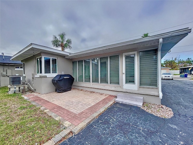 rear view of house featuring a patio and central AC