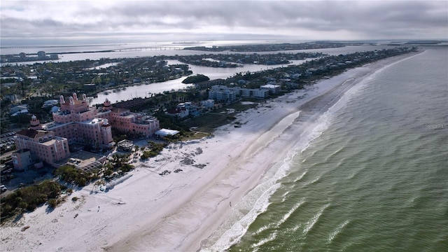 birds eye view of property with a water view and a beach view