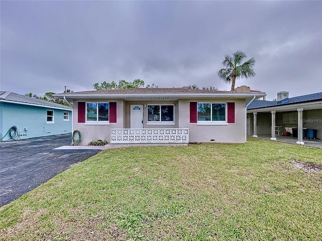 3505 Casablanca Ave, St Pete Beach, FL 33706 - view of front facade with stucco siding, a front lawn, and a porch