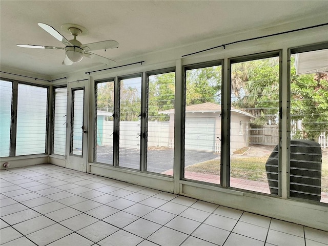 unfurnished sunroom featuring ceiling fan