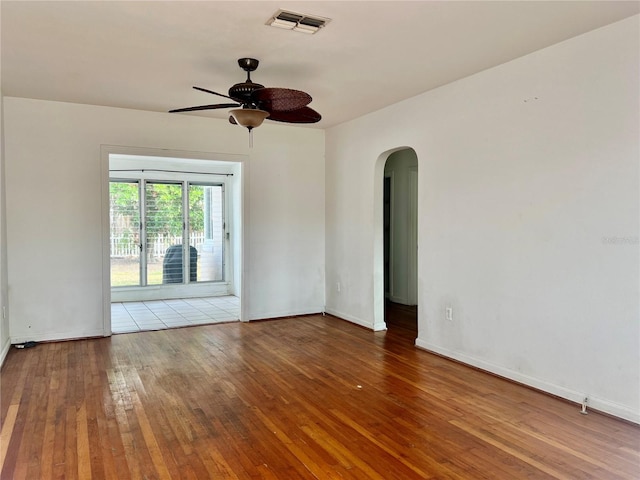 3505 Casablanca Ave, St Pete Beach, FL 33706 - spare room with arched walkways, ceiling fan, wood-type flooring, and baseboards