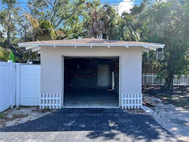 garage featuring fence and driveway