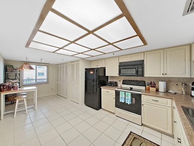 kitchen featuring decorative backsplash, light tile patterned floors, black appliances, and cream cabinetry