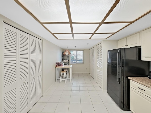 kitchen with black refrigerator and light tile patterned floors