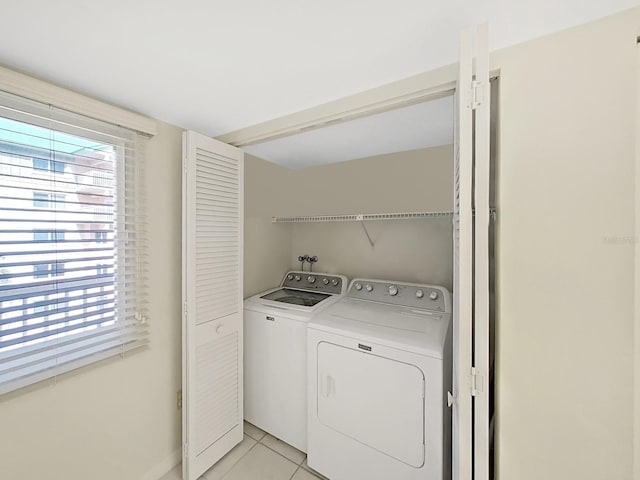 laundry room featuring independent washer and dryer and light tile patterned floors