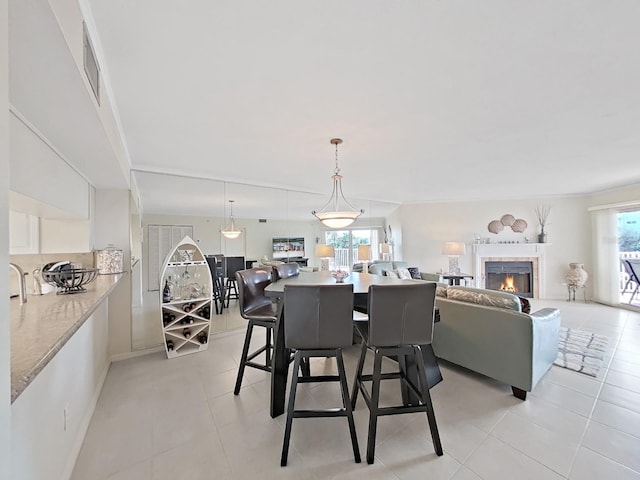 dining area with light tile patterned floors and a fireplace