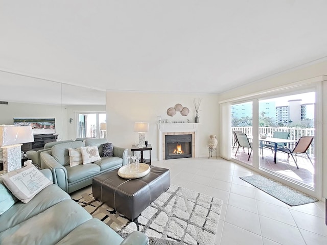 tiled living room featuring a fireplace, a wealth of natural light, and vaulted ceiling