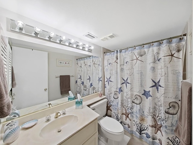 bathroom with walk in shower, vanity, and toilet