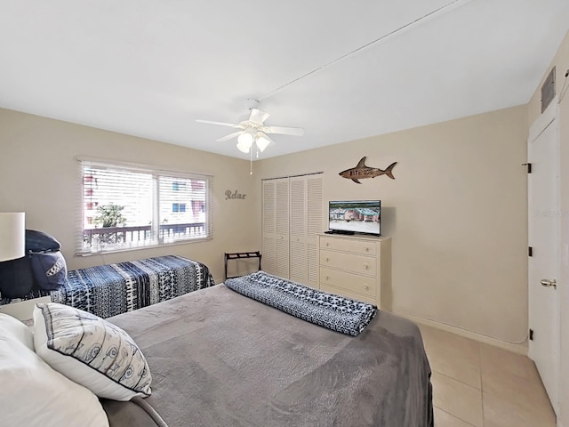 bedroom with ceiling fan, light tile patterned flooring, and a closet