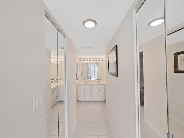 corridor with light tile patterned floors and sink