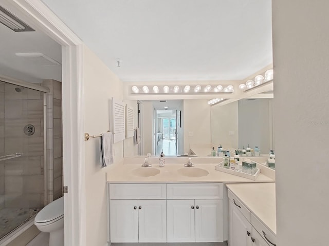 bathroom with vanity, toilet, and a shower with shower door