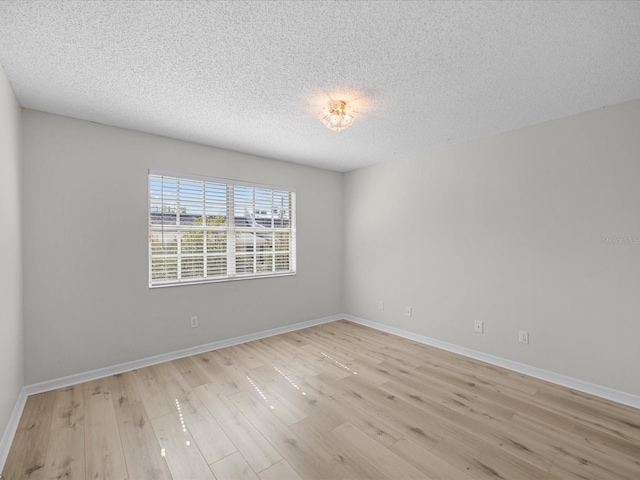 empty room featuring light hardwood / wood-style floors and a textured ceiling