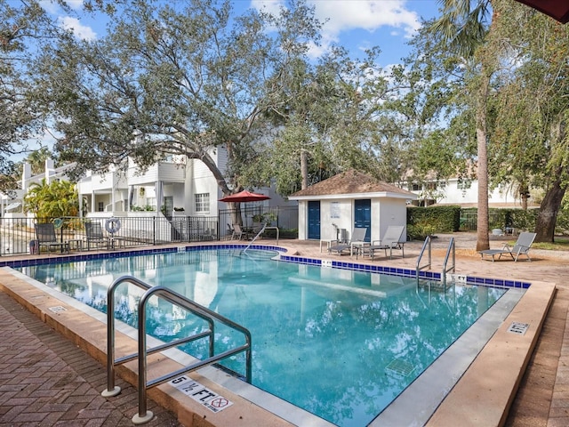 view of pool with an outbuilding and a patio