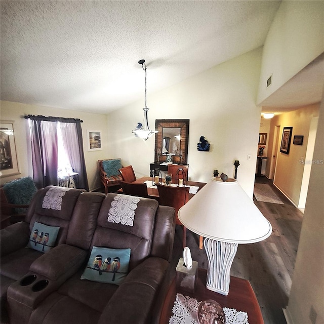 living room with dark wood-type flooring, vaulted ceiling, and a textured ceiling