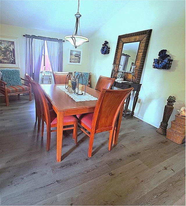 dining room featuring vaulted ceiling and dark hardwood / wood-style floors