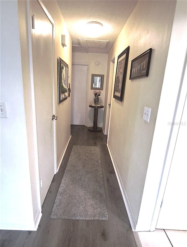 hall with dark wood-type flooring and a textured ceiling