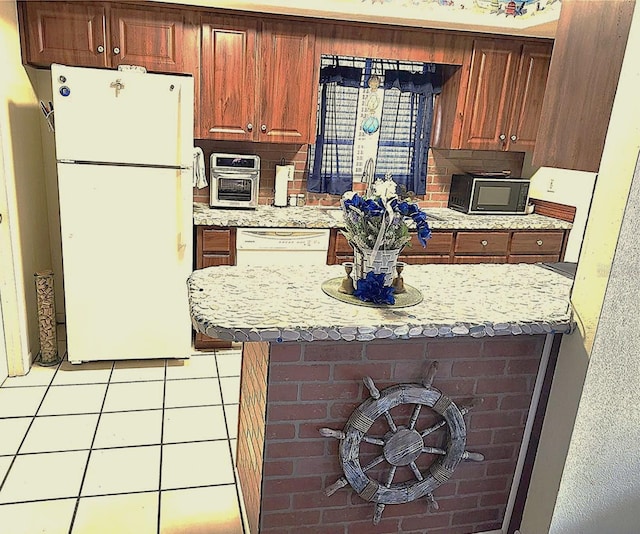 kitchen featuring light tile patterned floors and white appliances