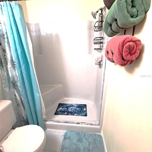 bathroom with curtained shower and toilet