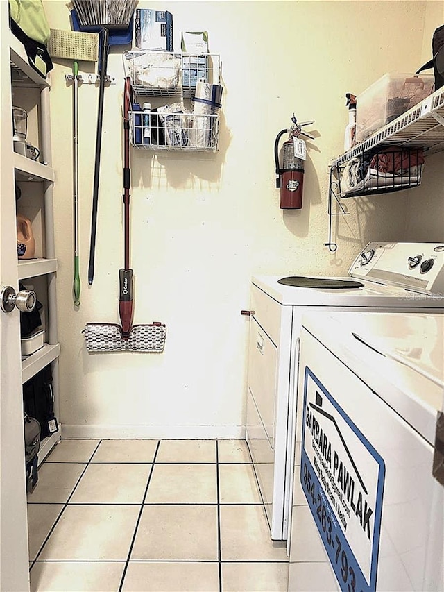 washroom with washing machine and dryer and light tile patterned flooring