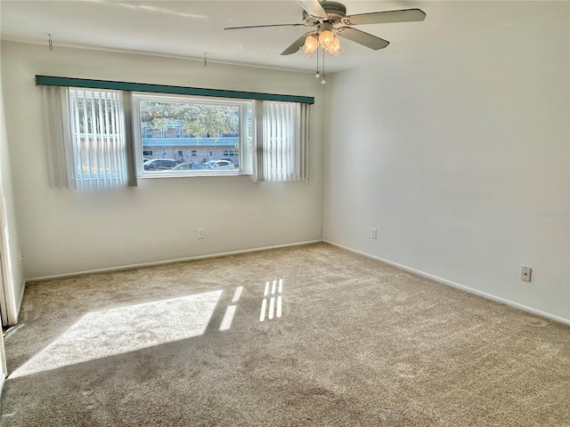 empty room featuring ceiling fan and light carpet