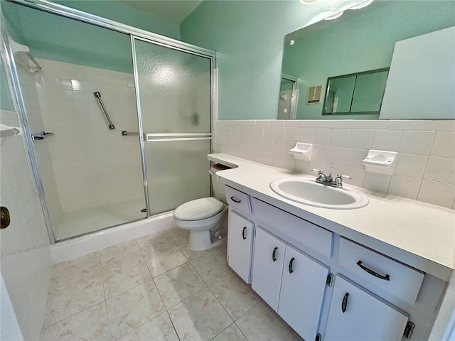 bathroom with vanity, tile patterned floors, toilet, tile walls, and an enclosed shower