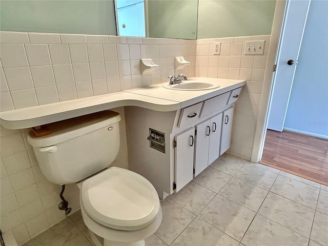 bathroom featuring tile patterned floors, vanity, tile walls, and toilet