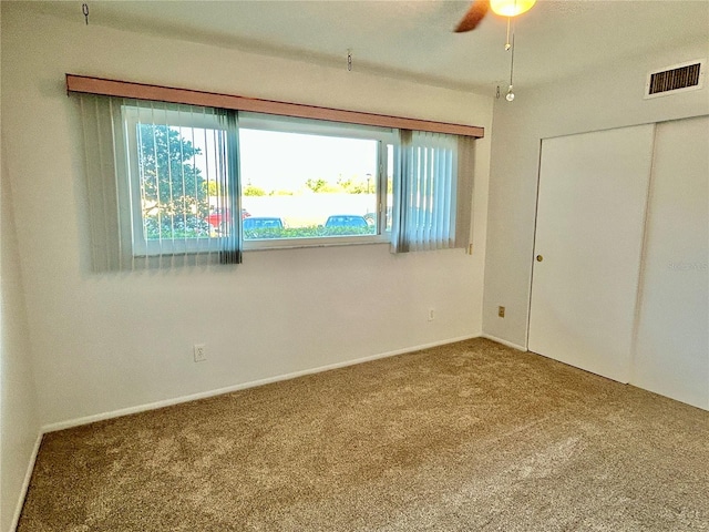 unfurnished bedroom with carpet floors, a closet, and ceiling fan