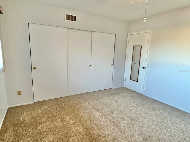 unfurnished bedroom with a closet and carpet floors