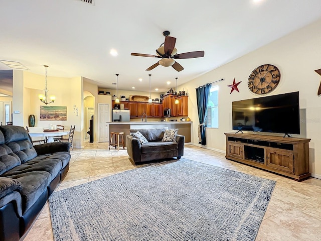 living room featuring ceiling fan with notable chandelier