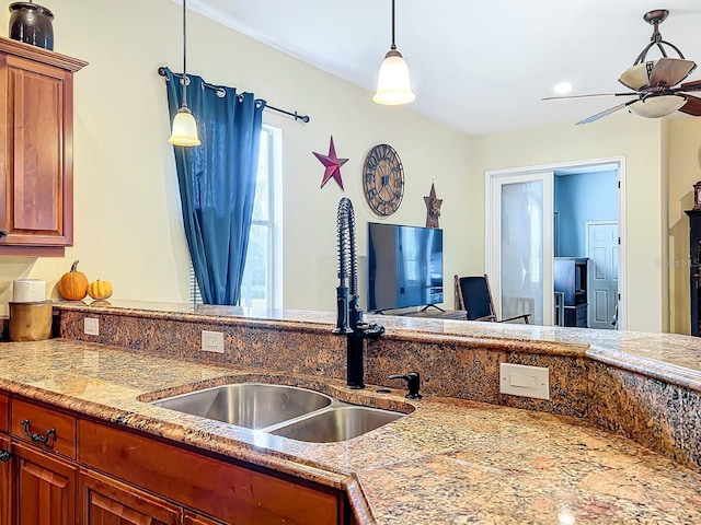 kitchen featuring ceiling fan, sink, and hanging light fixtures